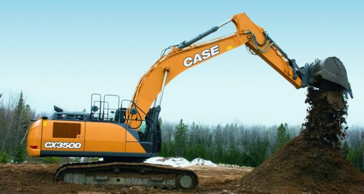 An Orange Case Excavator Sitting On Dirt At A Construction Site With An Overcast Sky Background And Trees In The Background.